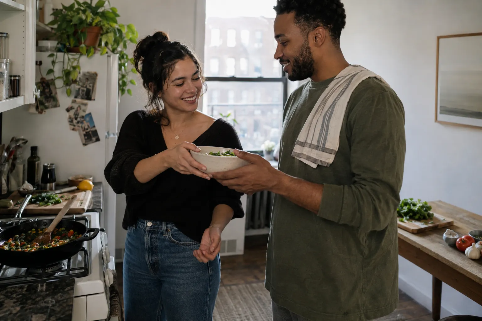 Two adults sharing a bowl while cooking together
